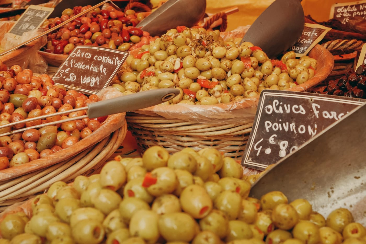 Paniers d'olives farcies et ardoises de prix sur un marché provençal de Saint-Tropez