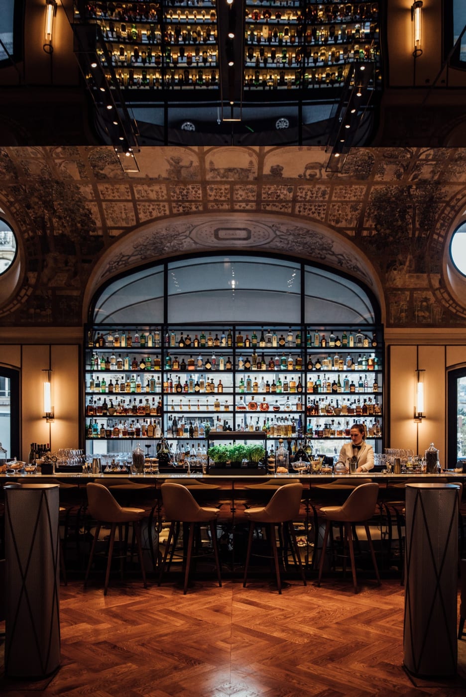El Bar Joséphine del Mandarin Oriental Lutetia, barra y botellas retroiluminadas bajo los frescos históricos