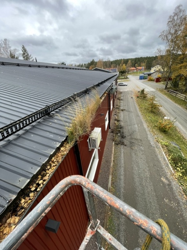 gammal röd bod i trädgård i Fjugesta, med fin grusgång som leder upp till dörrarna.