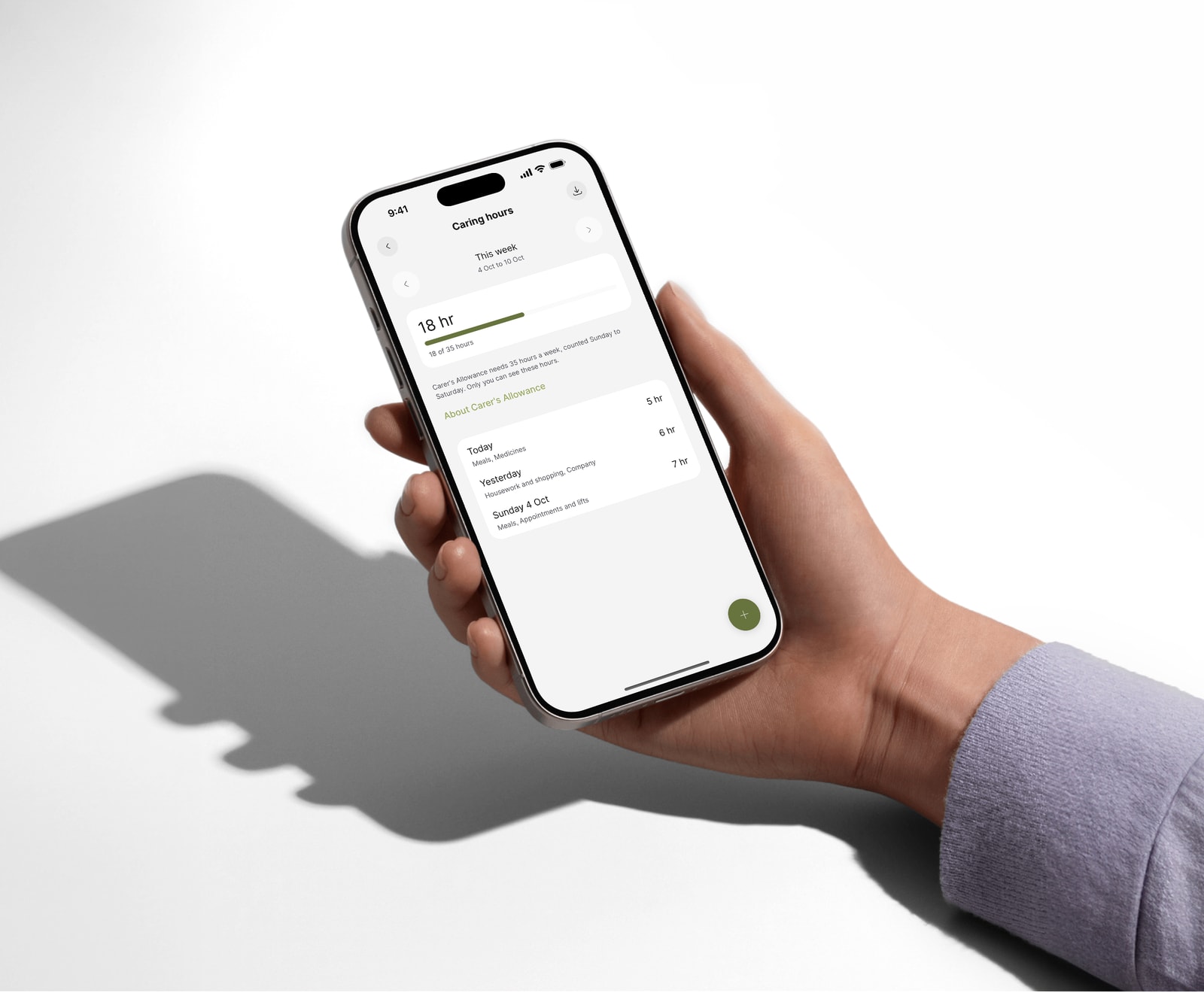 Hand holding an iPhone with Kinlog showing 18 hours of caring logged this week, with the days and what was done