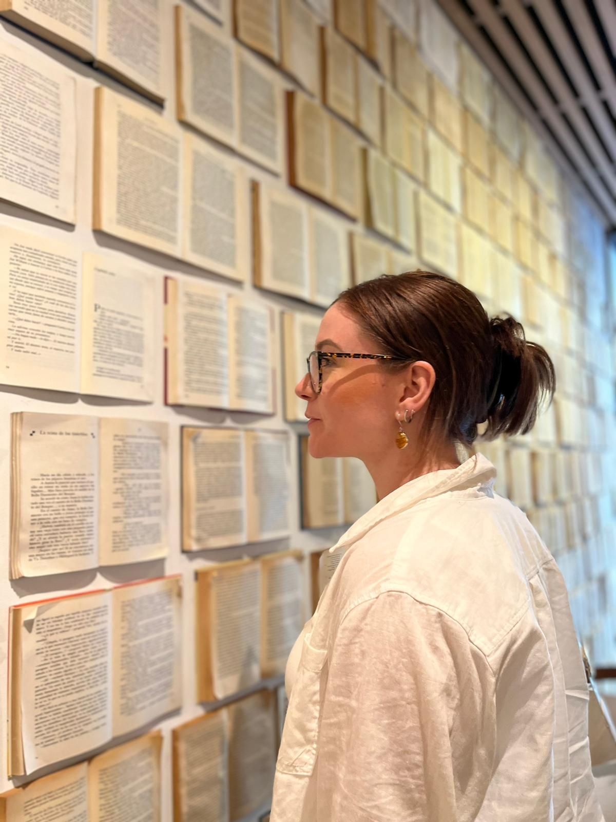 A woman looking at a wall of books