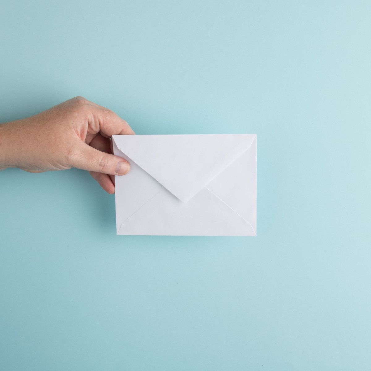 A hand holding an envelope