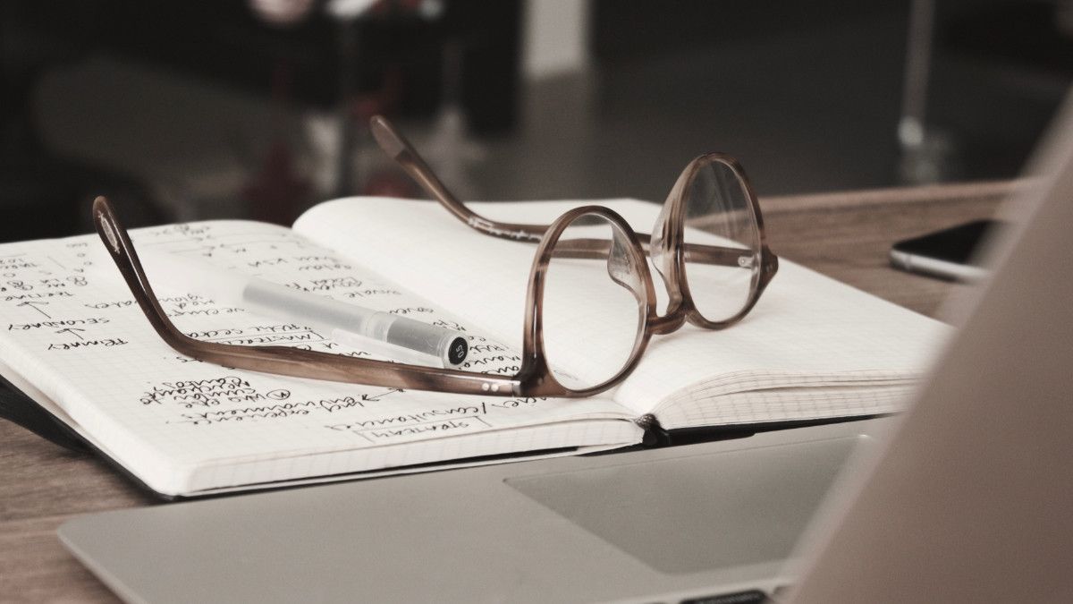 Reading glasses placed on top of a notebook