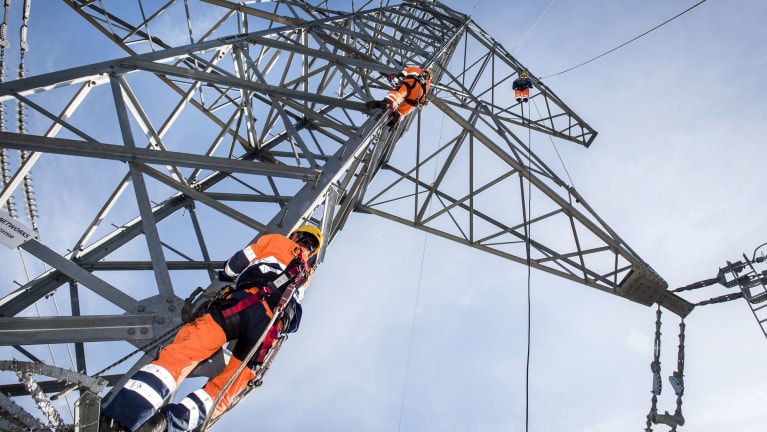 Overhead lines - workers on a lattice pole - Eltel Networks