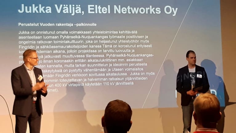 Eltelin Jukka Väljä vastaanottamassa Fingridin Vuoden rakentaja -palkintoa Timo Kiiveriltä Fingridin Kantaverkkopäivässä.