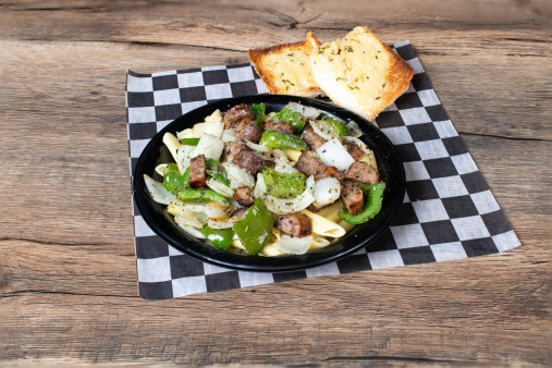 image of Italian Sausage, Peppers & Onions over Pasta