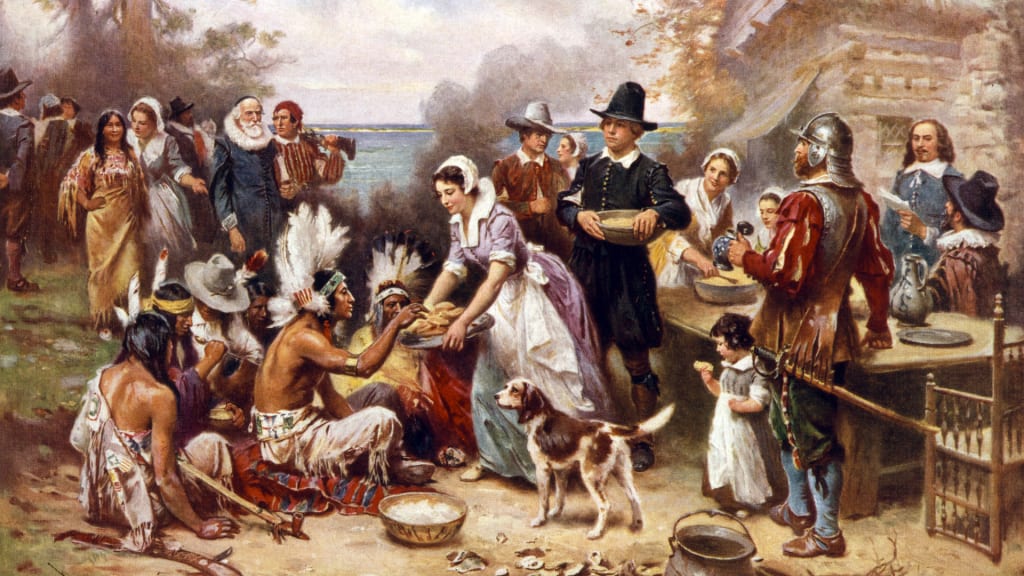 Painting of Pilgrims and Native Americans sharing food at the first Thanksgiving, with a Spaniel dog in the foreground