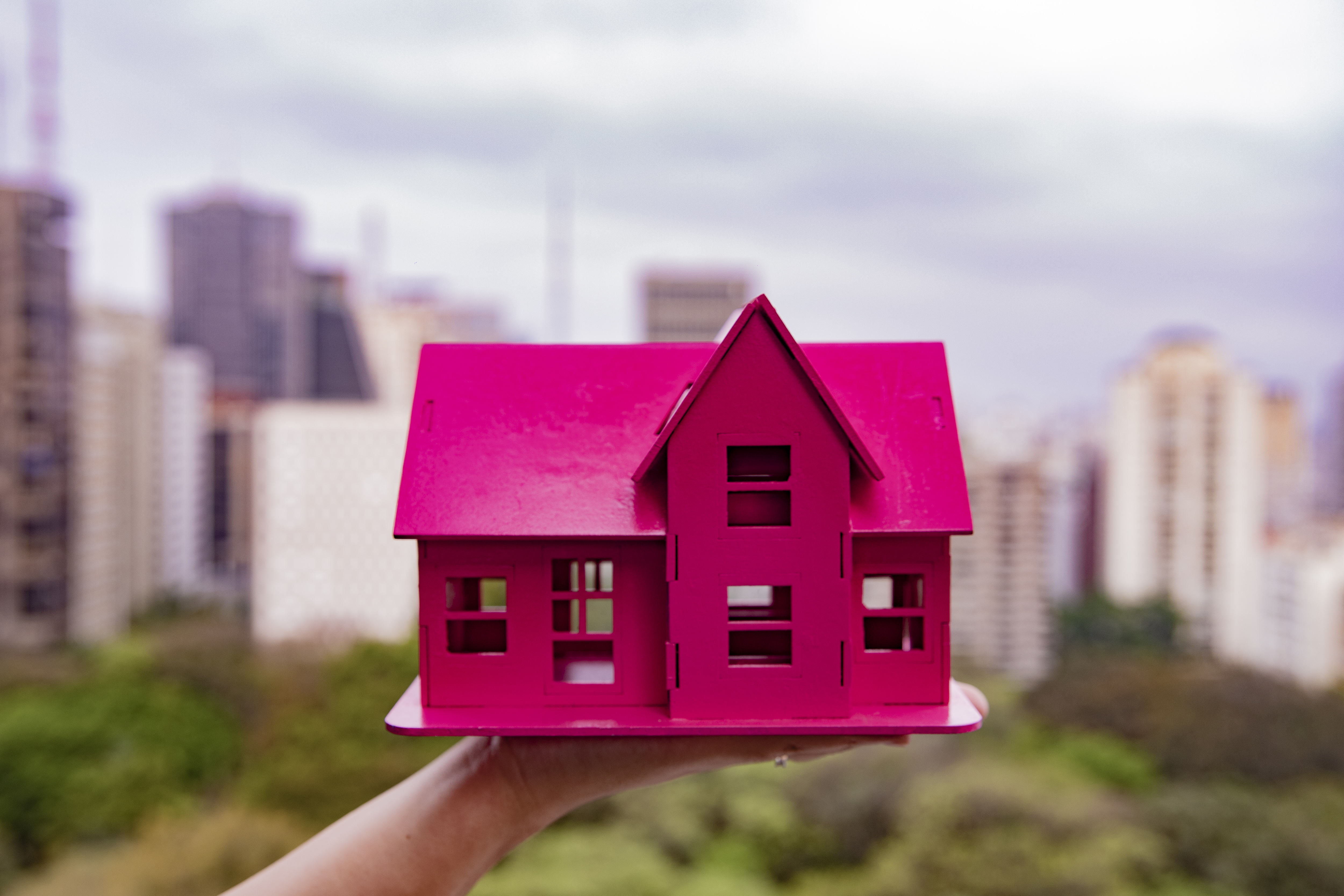 casa de maquete rosa com fundo de prédios