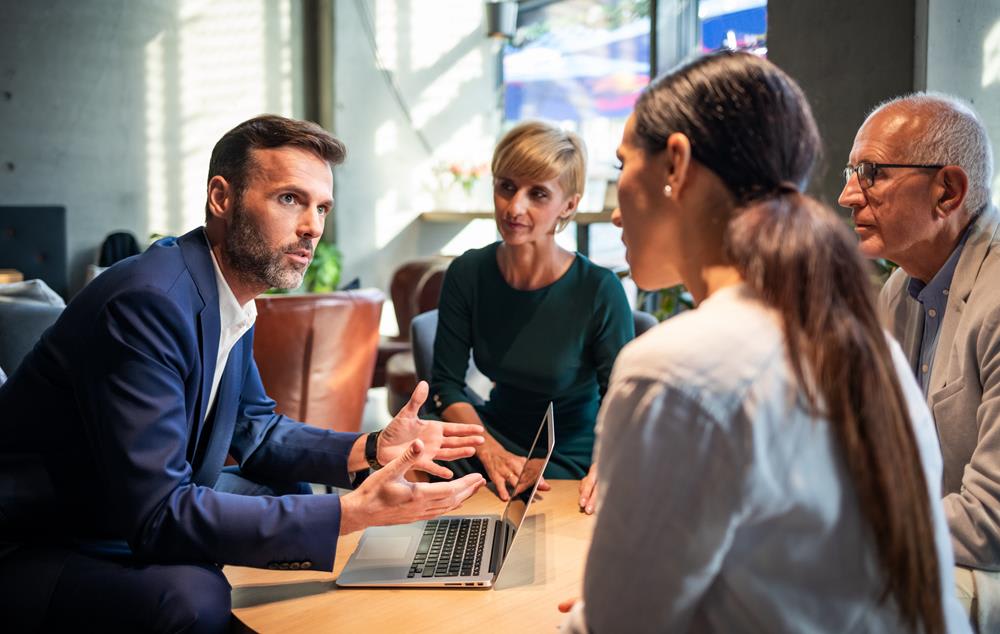 En grupp personer som diskuterar kring en dator. Foto: Shutterstock