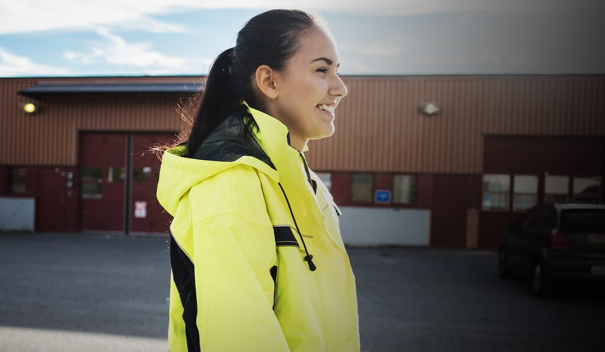 Glad kvinna i reflexjacka