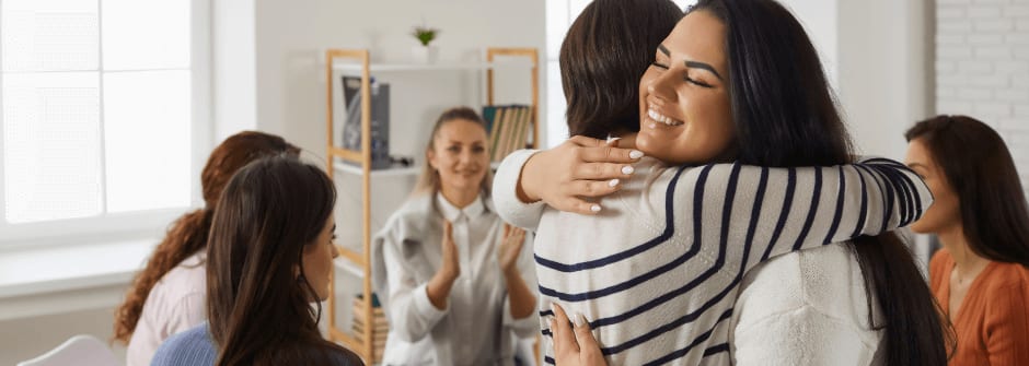 Positiivisen psykologian ohjaaja -koulutus Terapeutti halaa asiakasta.