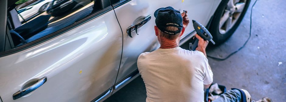 Ajoneuvoalan ammattitutkinto | vauriokorjauksen osaamisala mies korjaamassa autoa