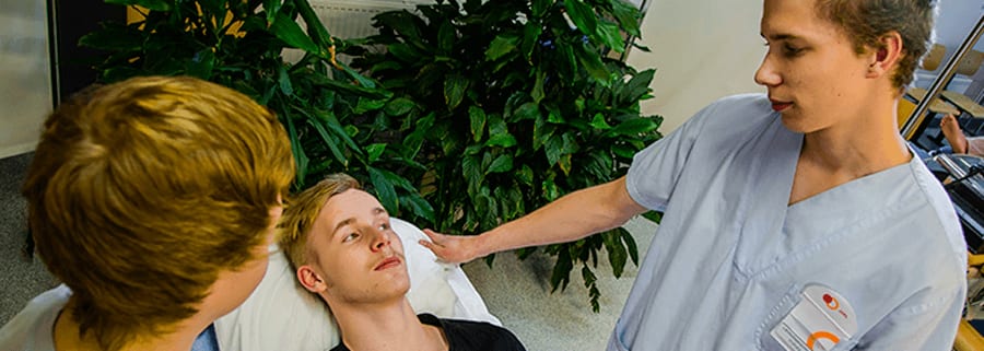 Sosiaali- ja terveysalan perustutkinto | lähihoitaja, perustason ensihoitaja Lähihoitaja tarkistaa potilaan vointia koulussa.