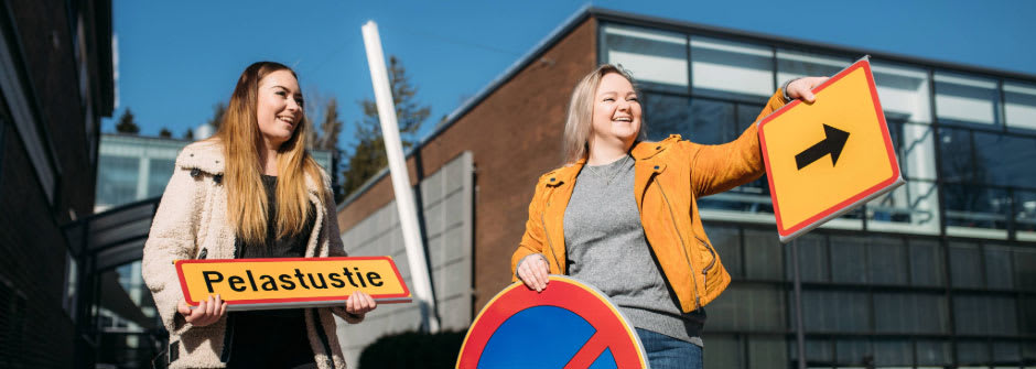 Liikennealan koulutus Kaksi opiskelijaa pitää liikennekylttejä