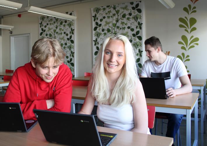 Huddingegymnasiet Bild på skolan och på elever som ler mot kameran