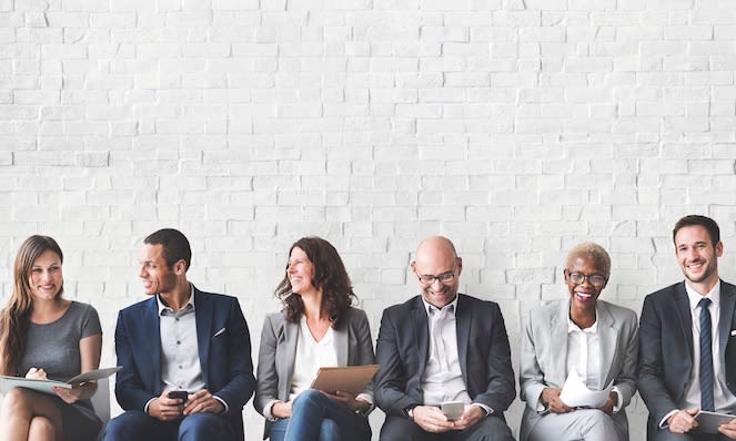 group of colleagues sitting against a wall