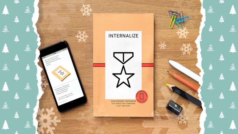 Achievement notebook with smartphone screen showing a chatbot conversation