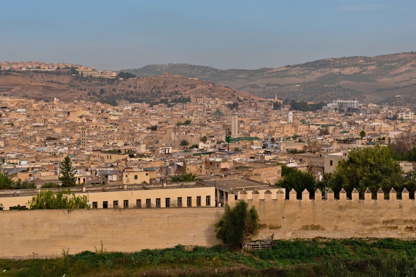 Panorama over the sand-colored rooftops, ramparts, and minarets of the ancient Fez medina