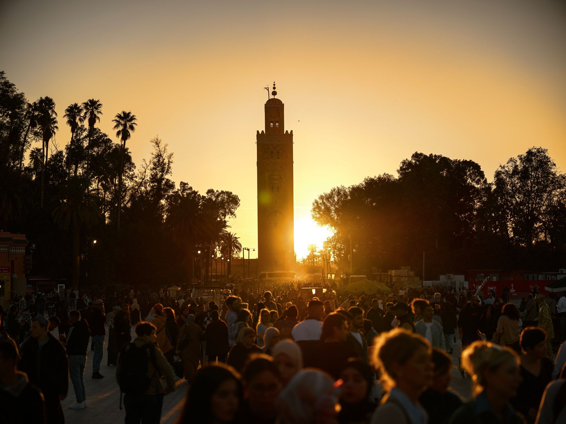 Koutoubia Mosque silhouetted against a golden Marrakech sunset above Jemaa el-Fnaa