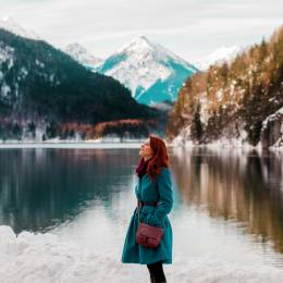 Young redhead girl in coat near lake in Alps, Germany Tours