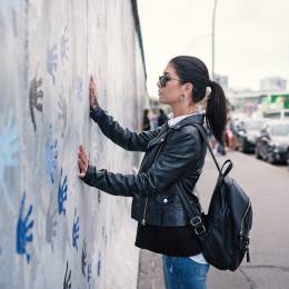 Enchanting Travels Germany Tours Young woman in front of Berlin Wall - German History