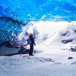 Traveler in ice cave, man standing underground inside of a glacier, climate specific, Vatnajokull National Park, amazing nature of Skaftafell, Iceland