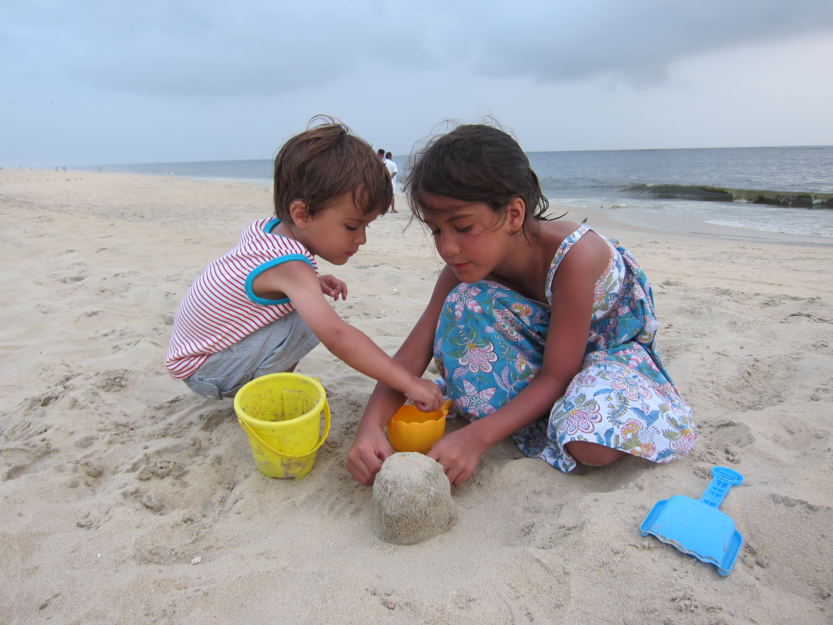 Ein kleiner Junge und ein kleines Mädchen spielen am Strand von Marari im Sand