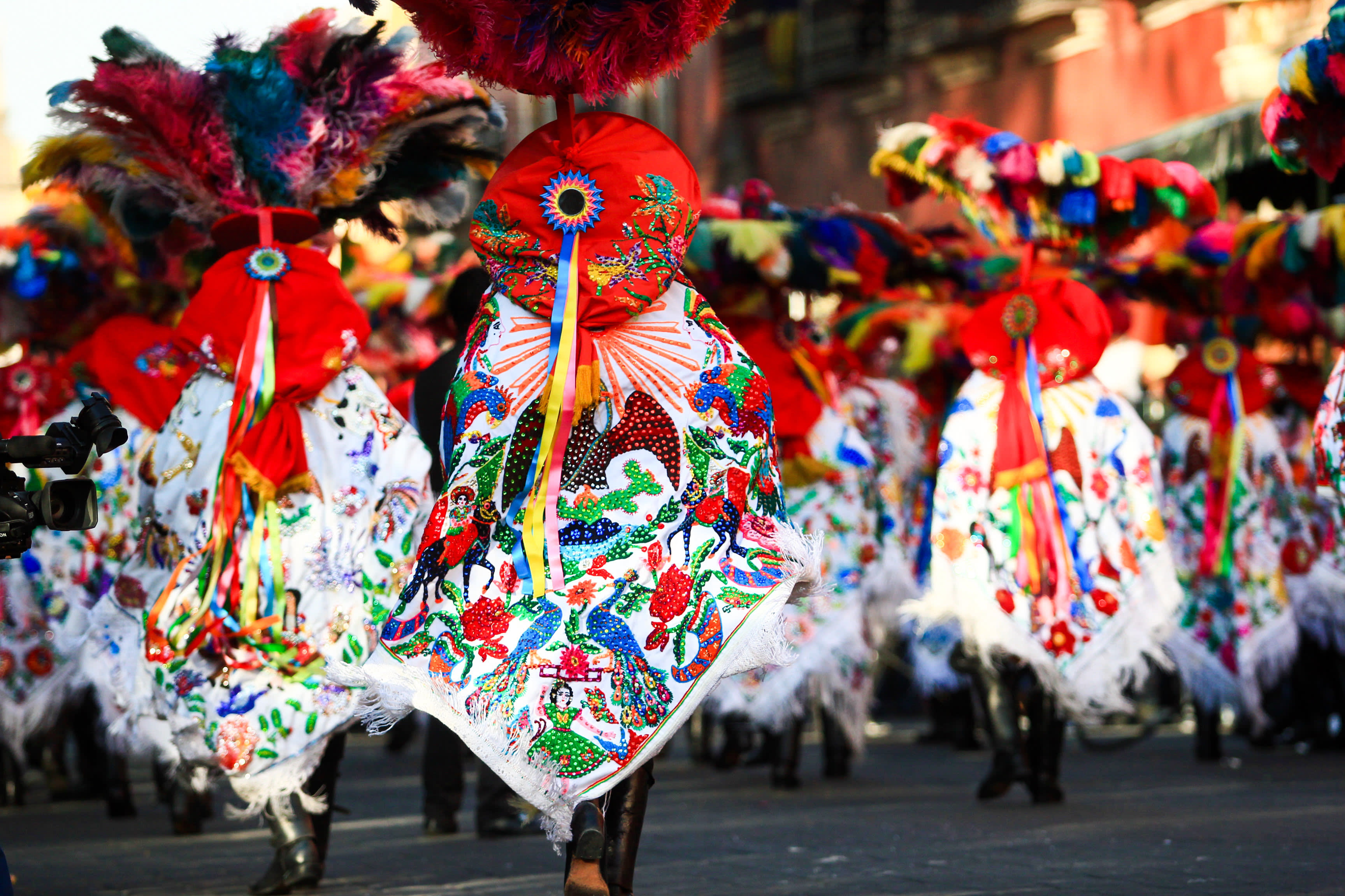 Horizontal photo of a Carnival scene, dancers wearing a traditional mexican folk with an amazing cape rich in color
