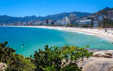 Strand von Rio de Janeiro mit türkisblauem Wasser und Gebirge