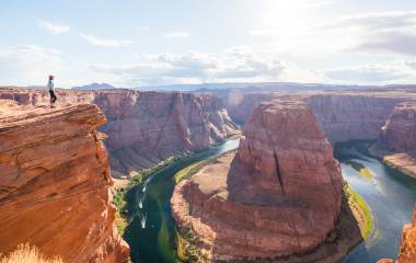 Woman stands over Horseshoe Bend, Grand Canyon