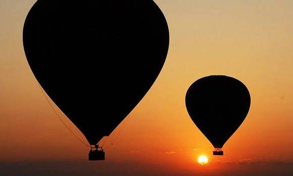 Schatten von Bagan Ballons, während im Hintergrund die Sonne aufgeht