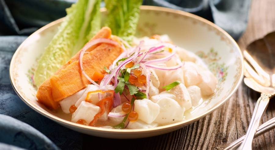 Peruvian ceviche with halibut and roe plated in a classic dish on rustic wood
