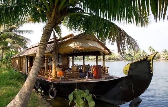 Hausboot mit Strohdach am Flussufer in Kerala, Indien