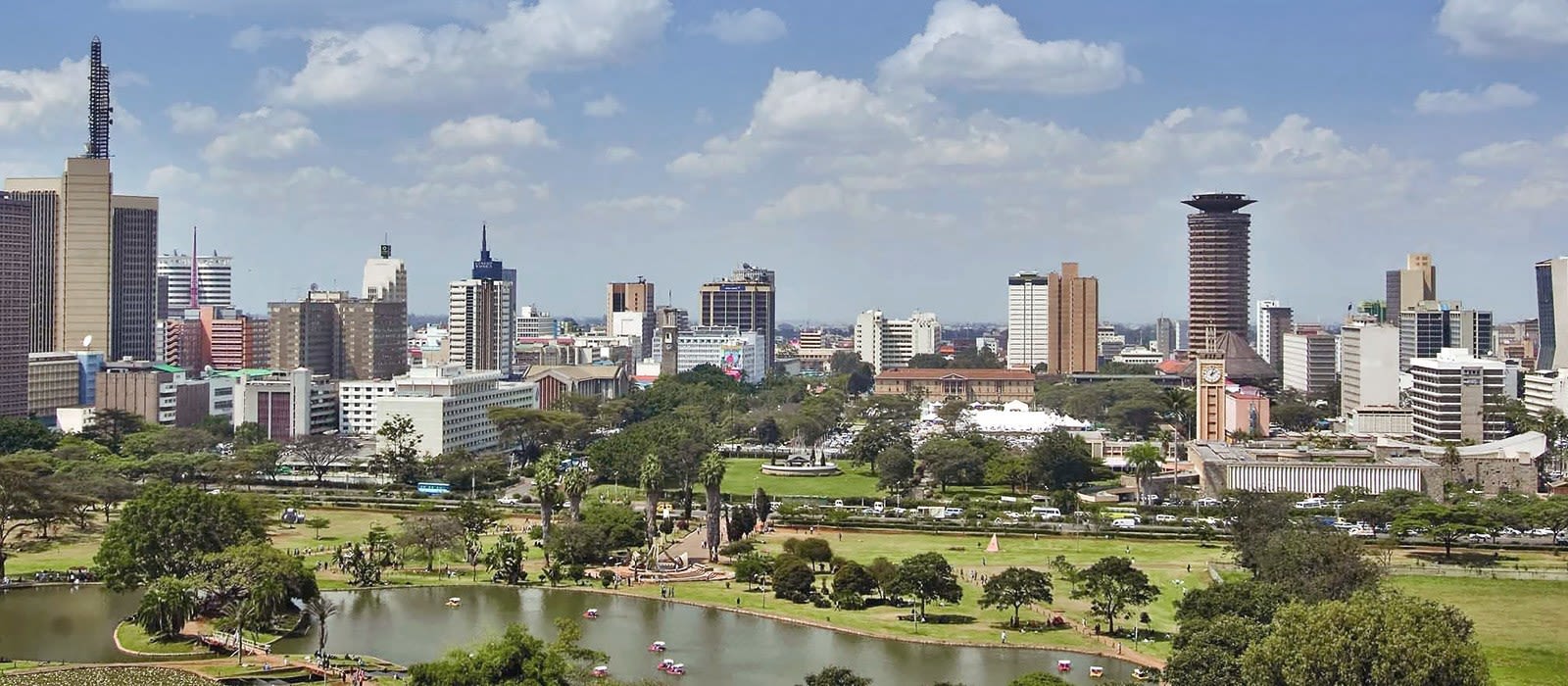 Nairobi city skyline featuring tall buildings and a lush green park in the foreground.