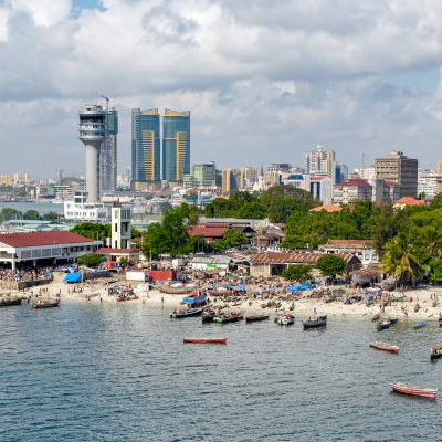 Fisherman boats in front of Kivukoni fish market with Port control tower and Skyscrapers Behind, Dar Es Salaam, Tanzania