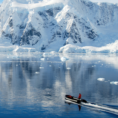 Boat dwarfed by antarctic mountains