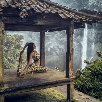 Woman practices yoga at Sekumpul waterfall on Bali in indonesia, Asia