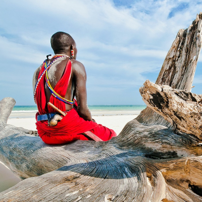 Enchanting Travels Tanzania Tours Man from the Maasai tribe sits on the shore of the Indian ocean - culture of Tanzania
