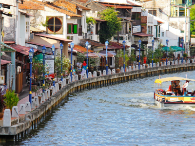 a group of people on a boat in the water with San Antonio River Walk in the background