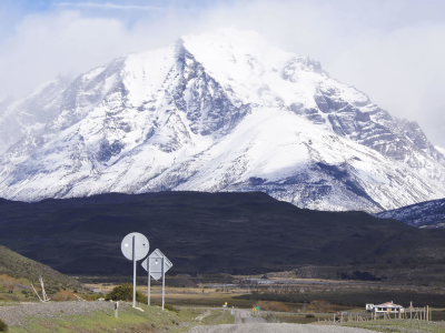 a sign on the side of a snow covered mountain