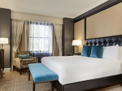 a bedroom with a bed and desk in a room