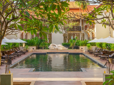 a group of palm trees with a building in the background