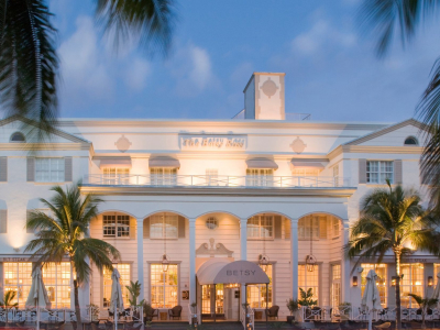 a group of palm trees with a building in the background