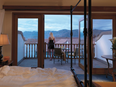 a bedroom with a bed and a chair in front of a window