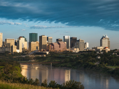 a bridge over a body of water with a city in the background