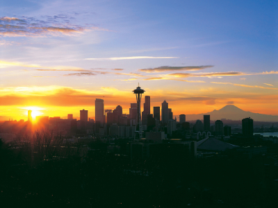 a sunset over a body of water with a city in the background