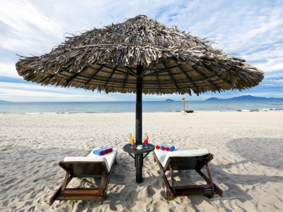 a person sitting at a beach umbrella in the snow