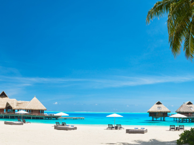 a group of lawn chairs sitting on top of a sandy beach