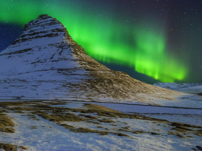 Northern lights over a mountain in Kirkjufellsfoss, Iceland