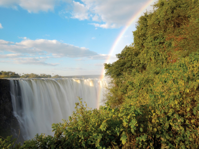 Färgglad regnbåge som går ner över Victoriafallen, Zimbabwe